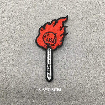 Flame-tipped match with skull design on a gray background