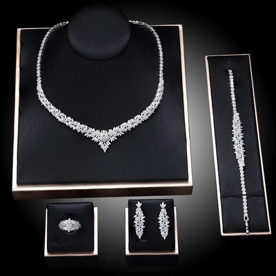 Jewelry set including necklace, bracelet, earrings, and ring on a black display cards