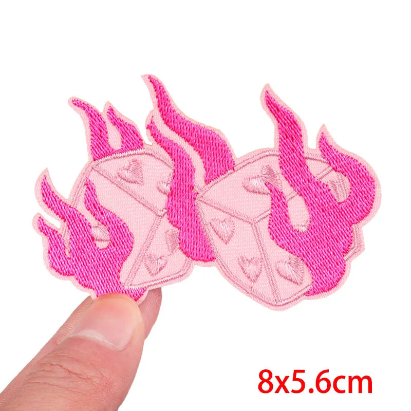 Pink flame-patterned patches held by a finger on a white background