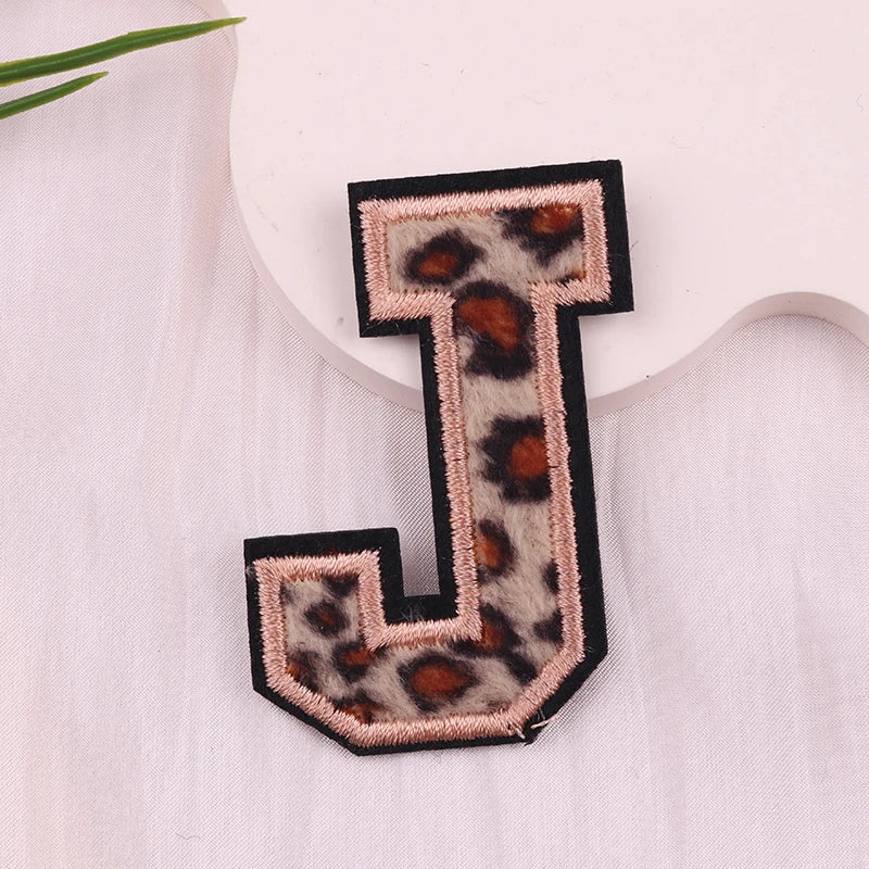 Leopard print letter 'J' patch on a white fabric background