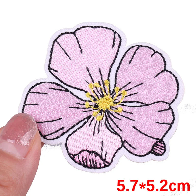 Floral patch held by a hand with dimensions displayed