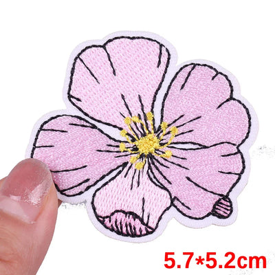 Floral patch held by a hand with dimensions displayed
