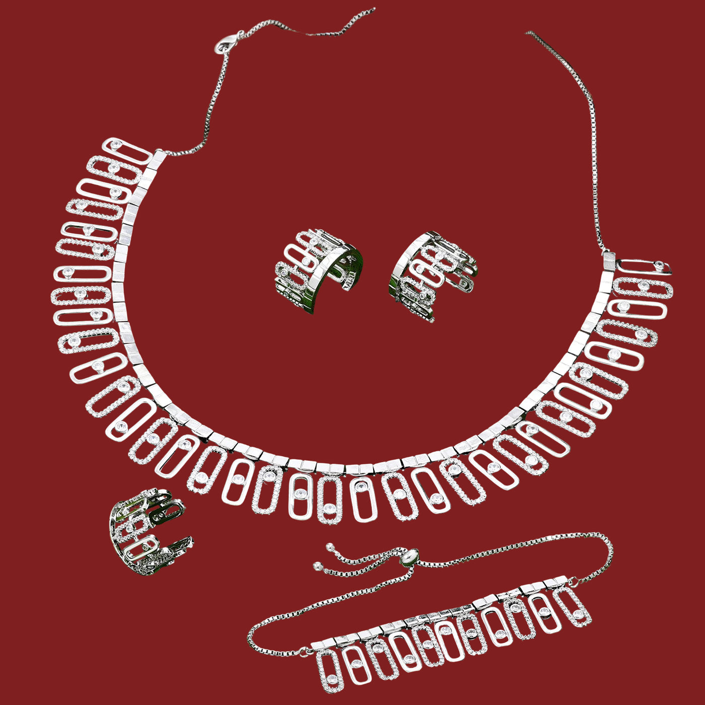 Silver necklace, earrings bracelet and ring set on a red background 