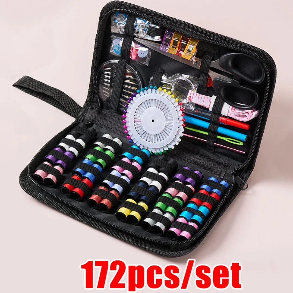 Open black sewing kit with various sewing supplies on a light pink background, labeled &