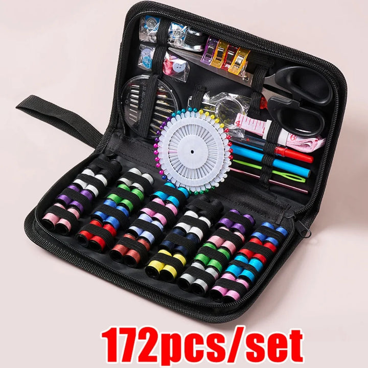 Open black sewing kit with various sewing supplies on a light pink background, labeled &