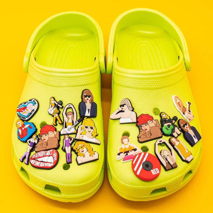 Yellow clogs with various colorful pins on a yellow background