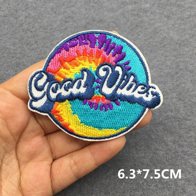 Colorful patch with 'Good Vibes' text held in a hand on a gray background