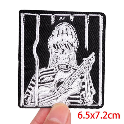 Embroidered patch of a skeleton with crossed rifles held by a hand, size 6.5x7.2cm.