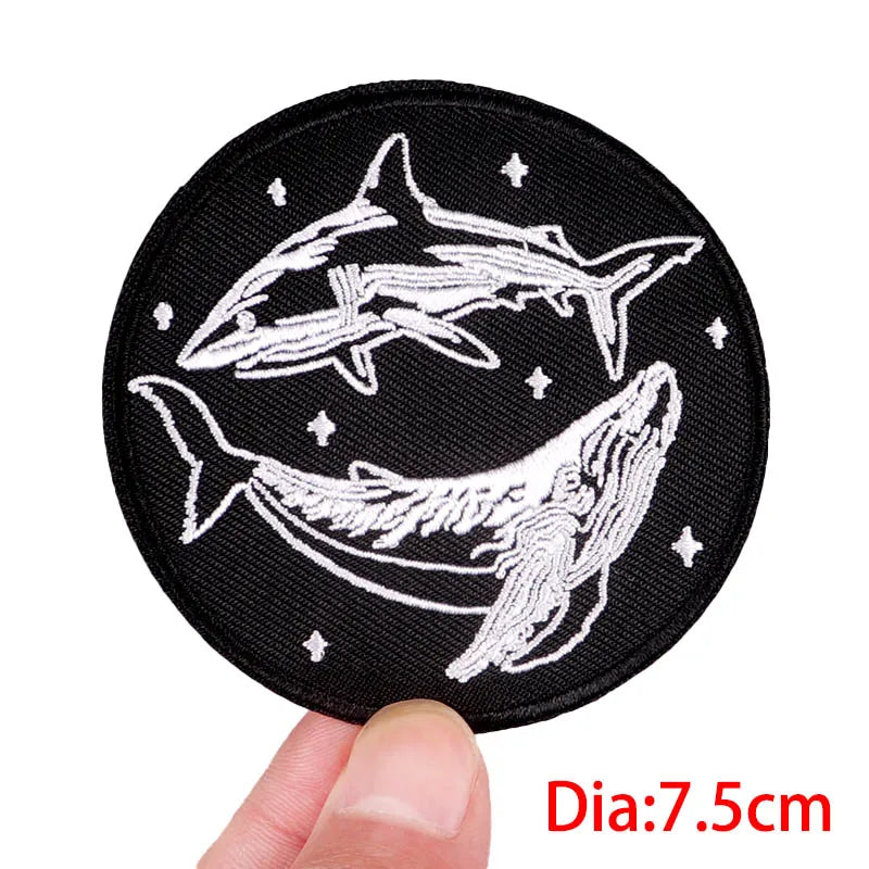 Black round patch with white shark design held by a hand, labeled 'Dia:7.5cm'.