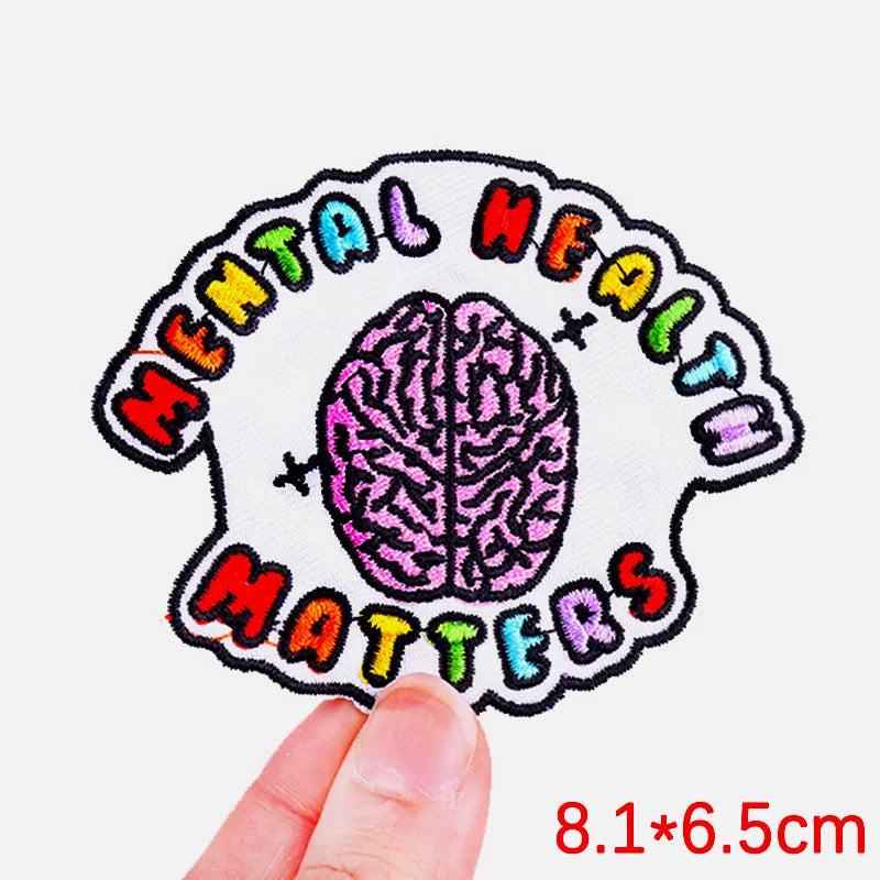 Patch with brain design and 'Mental Health Matters' text held by a hand on a white background
