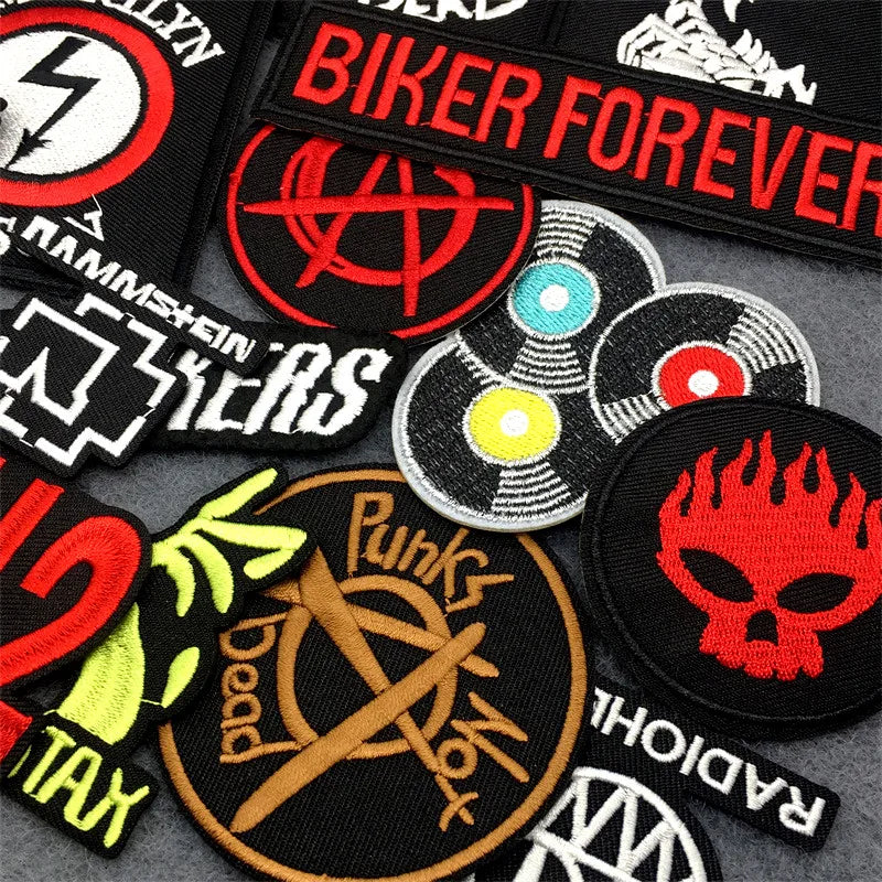 Collection of various patches with different designs and text on a gray surface.