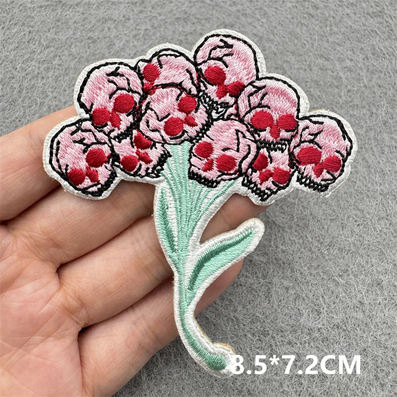 Floral patch held by a hand on a gray background