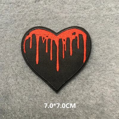 Heart-shaped patch with red dripping design on a gray background