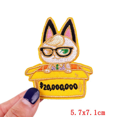 Embroidered patch of a cat character with glasses and a yellow box labeled '$20,000,000' held by a hand.