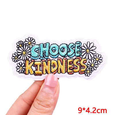Patch with 'CHOOSE KINDNESS' text held by a hand on a white background