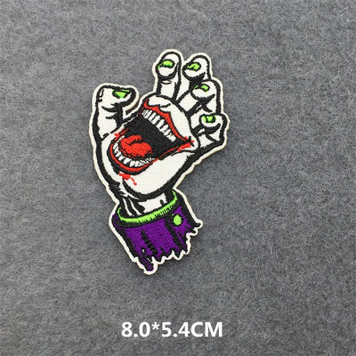 Embroidered patch of a hand holding a heart on a gray background