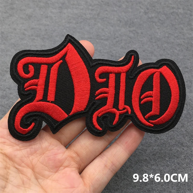 Red and black 'DIO' patch held in a hand with a gray background