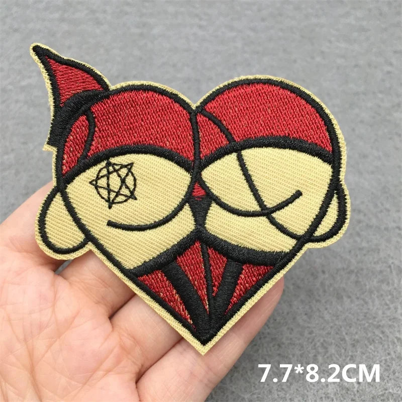 Embroidered patch with red and beige design held in a hand on a gray background