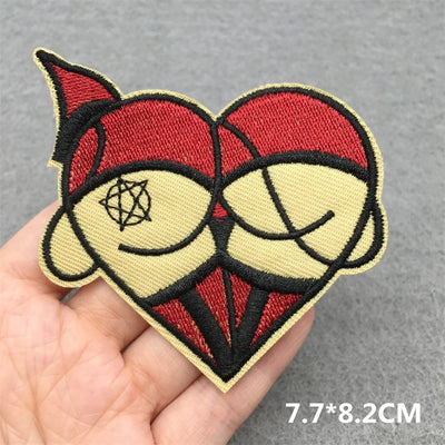 Embroidered patch with red and beige design held in a hand on a gray background