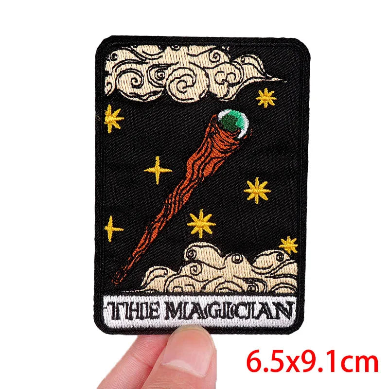 Embroidered patch of 'The Magician' from tarot cards held by a hand, with dimensions displayed.