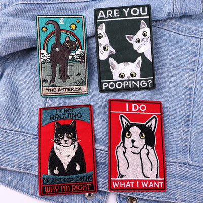 Four cat-themed patches on a denim jacket