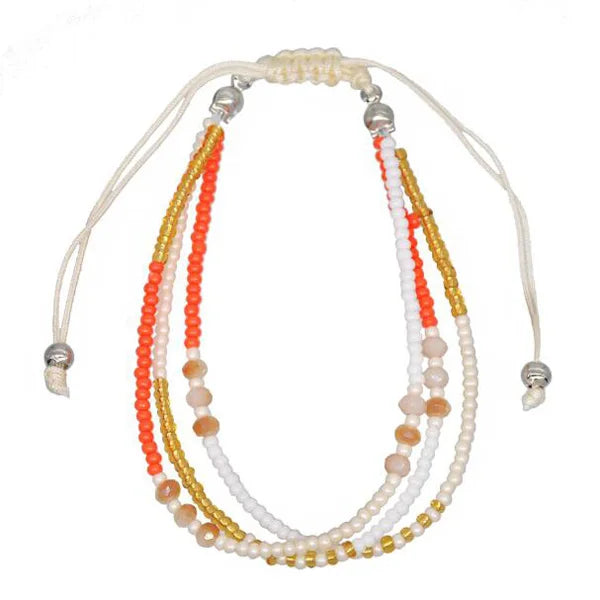 Multistrand beaded necklace with white, orange, and gold beads on a white background