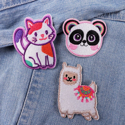 Three colorful animal patches on a denim background