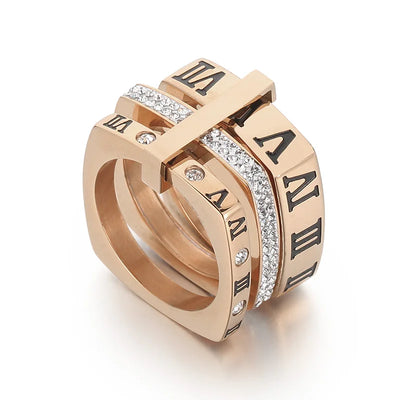 Rose gold ring with Roman numeral design on a white background