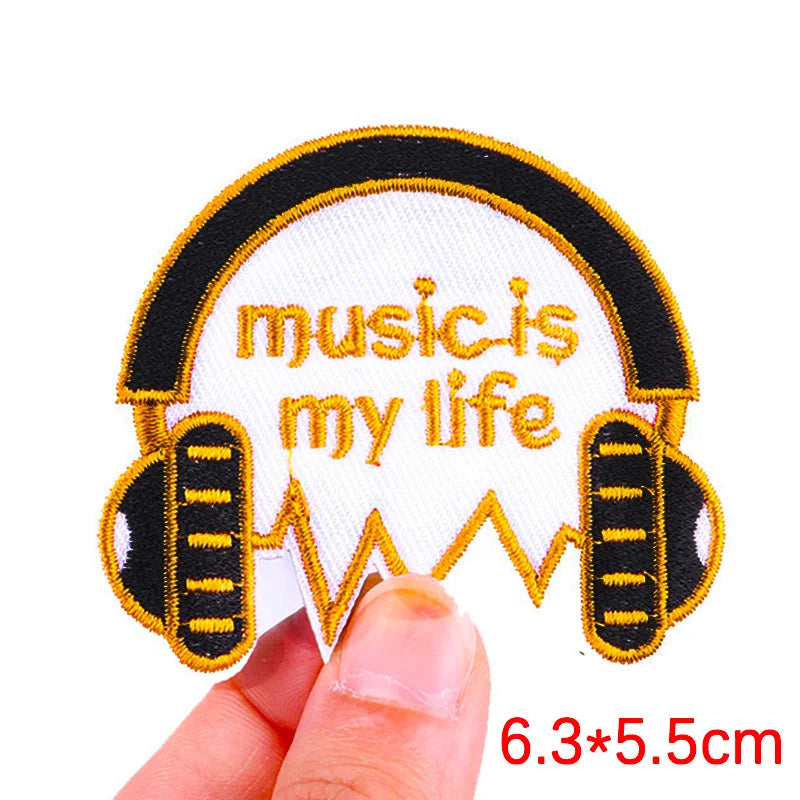 Embroidered patch with 'music is my life' text and headphones design held by a hand.