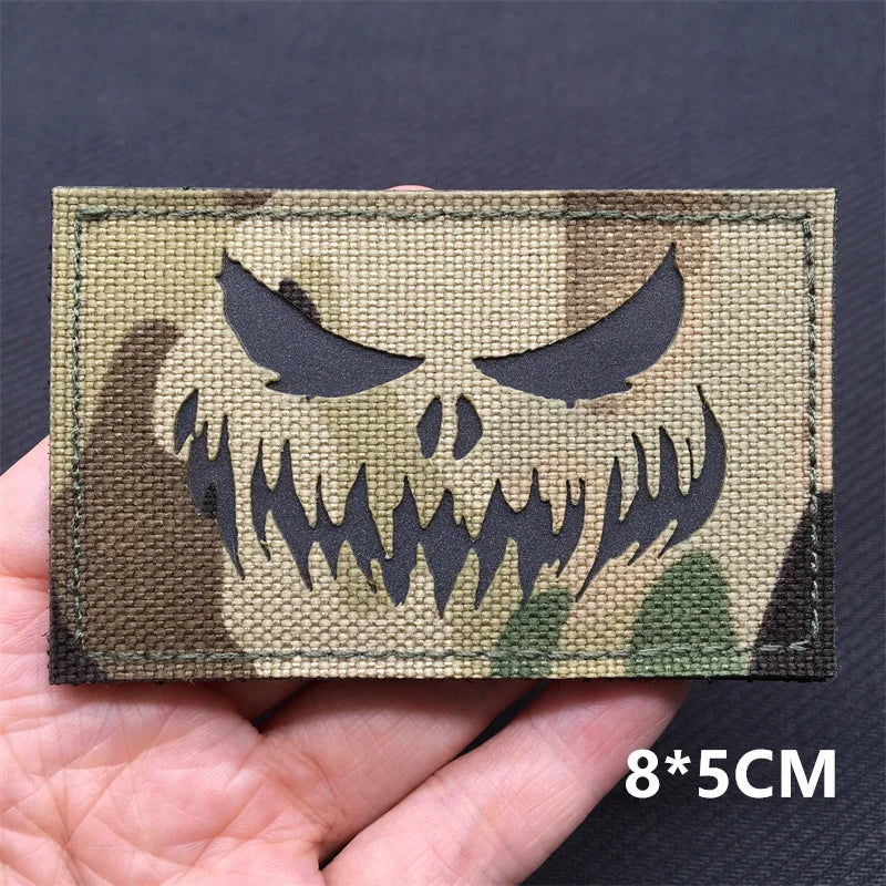 Camo patch with skull design held in hand against a dark background