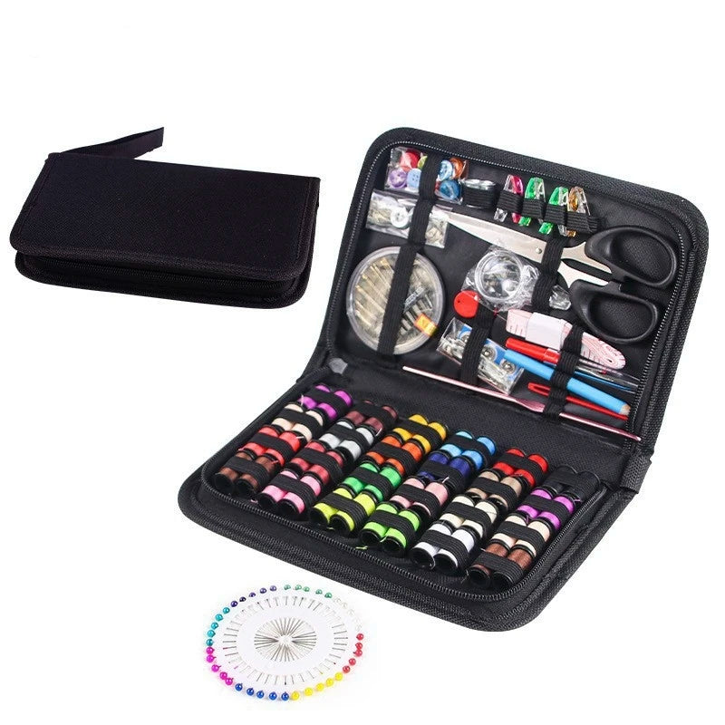 Sewing kit with threads, scissors, and other tools in a black case on a white background.