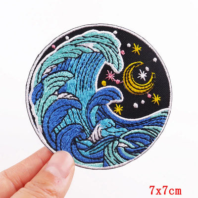 Embroidered patch with wave design held by a hand on a white background