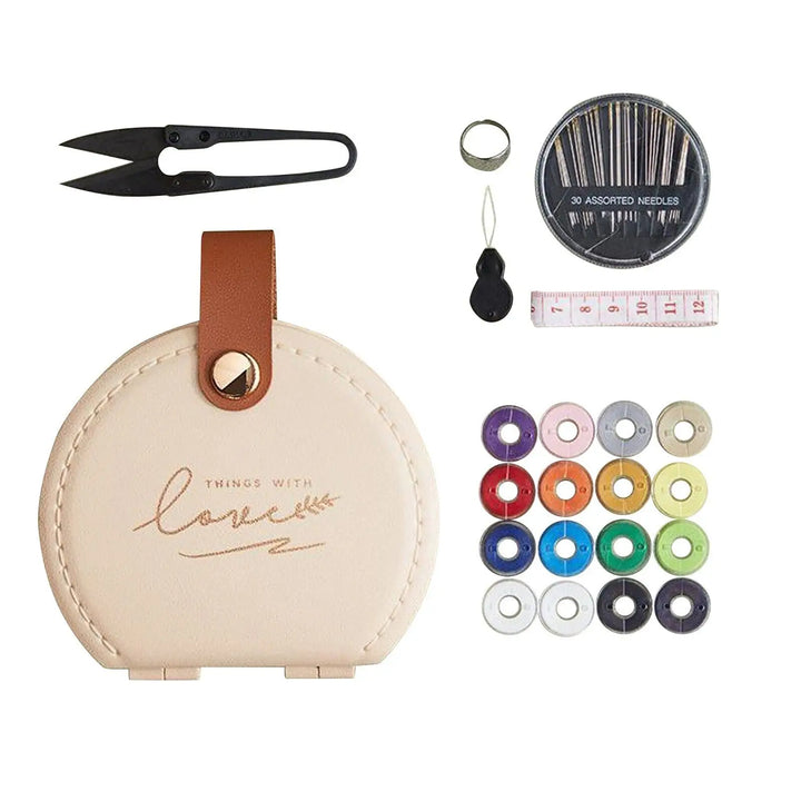 Sewing kit with apricot/beige case, scissors, needles, thread, and measuring tape on a white background