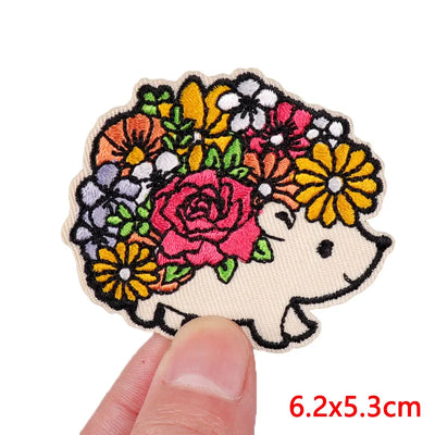 Embroidered patch of a hedgehog with flowers on a white background
