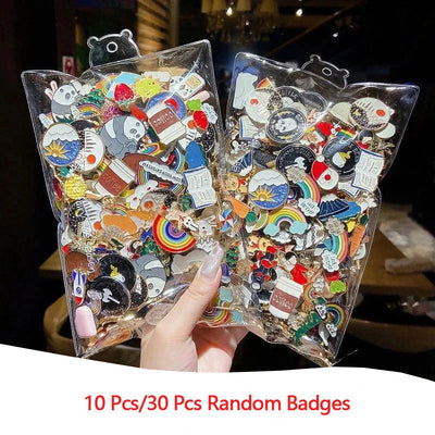 Two clear plastic bags filled with colorful badges held by a hand, with text indicating quantity.
