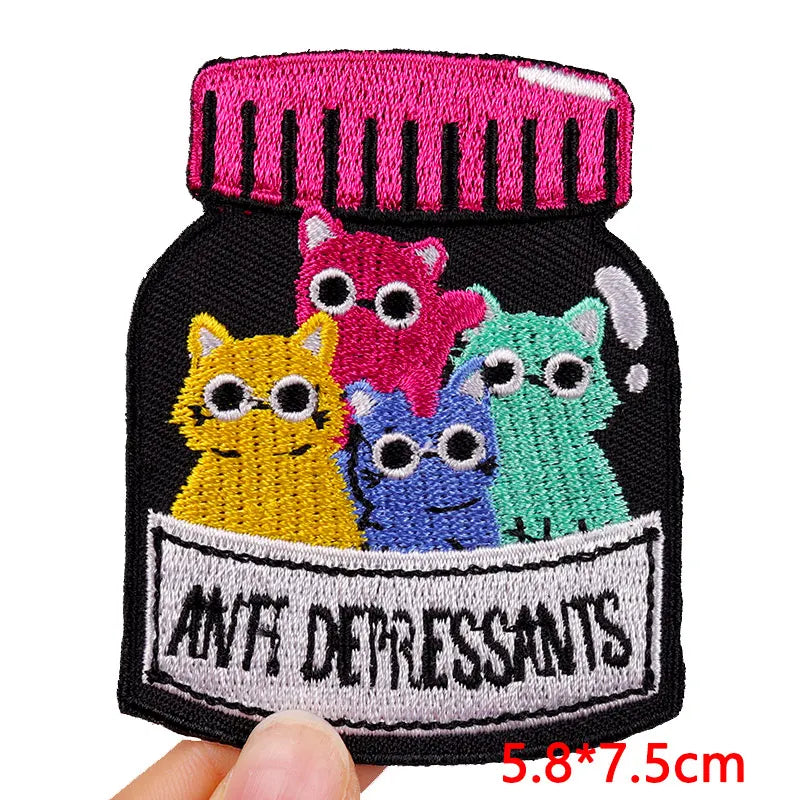 Embroidered patch of a jar labeled 'Anti Depressants' with colorful cats on a white background.