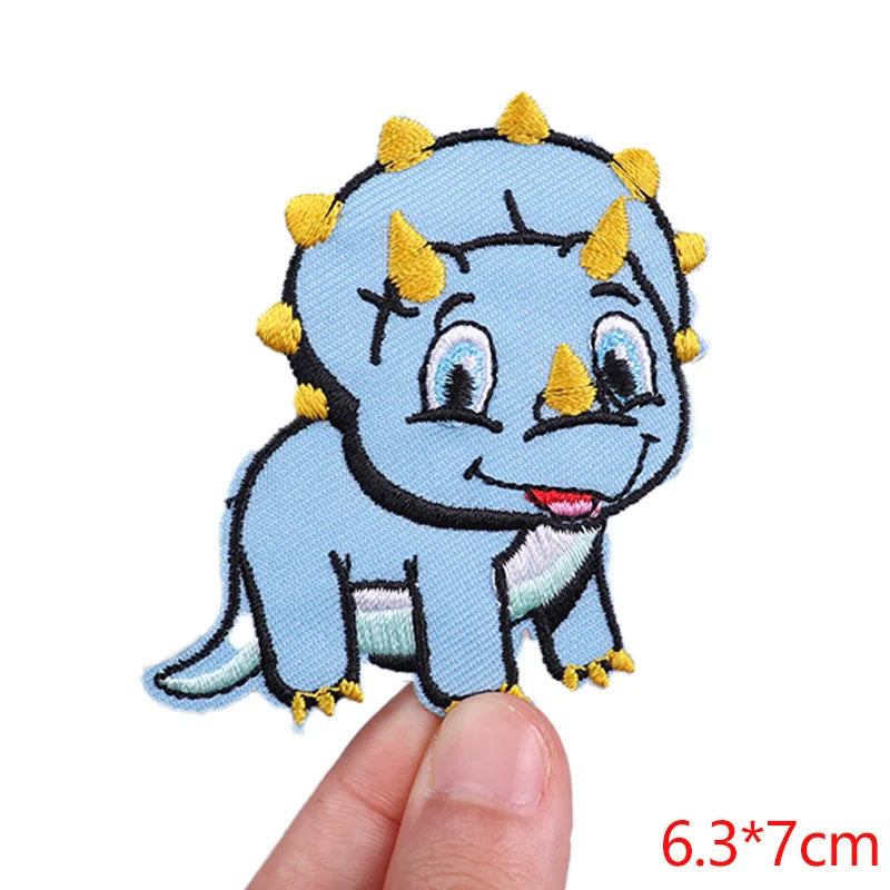 Blue cartoon dinosaur patch held by a finger on a white background