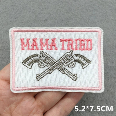 Embroidered patch with 'MAMA TRIED' text and crossed guns on a gray background