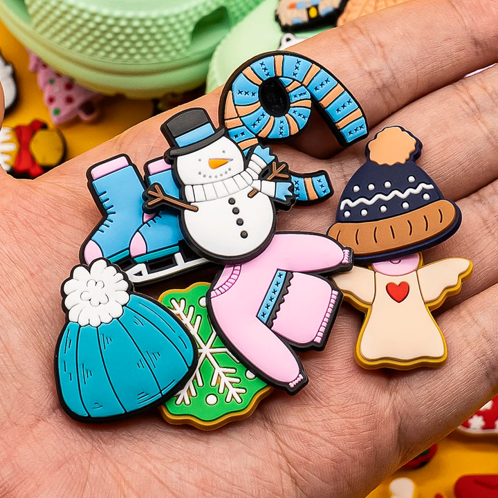 Colorful Christmas-themed shoe pins on a hand with a blurred background