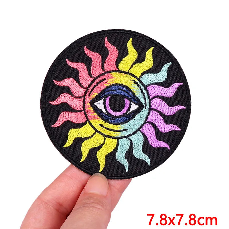 Colorful sun and eye design patch held by a hand with size label &