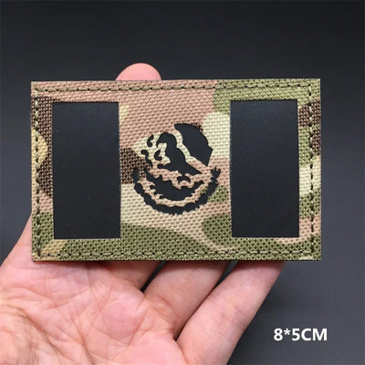 Mexico flag Camouflage patch held in a hand against a dark background
