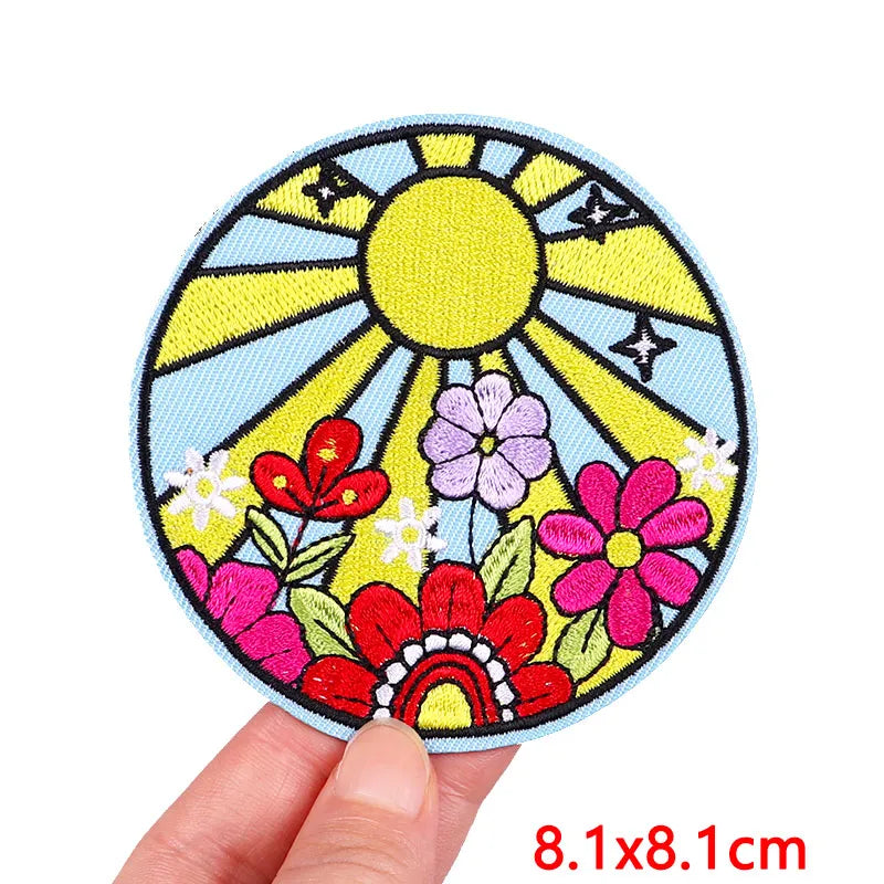 Colorful patch with sun and flowers held by a hand, size 8.1x8.1cm.