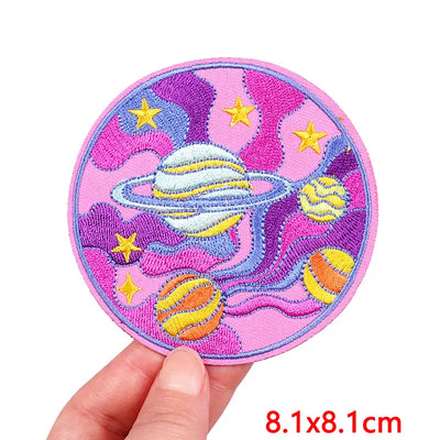 Colorful space-themed patch held by a hand with dimensions displayed.