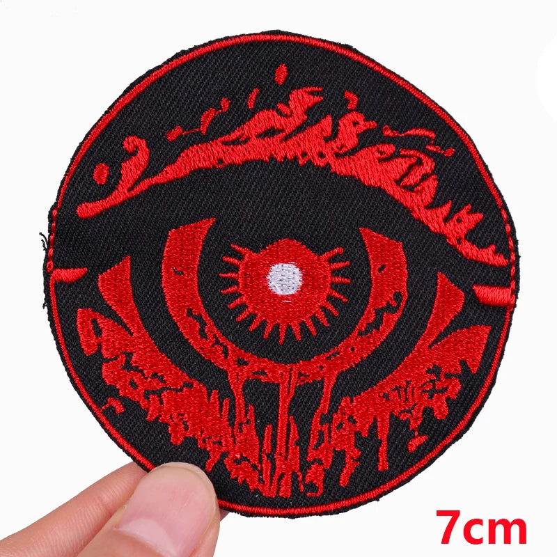 Circular red and black embroidered patch held by a hand with a measurement label indicating 7cm.