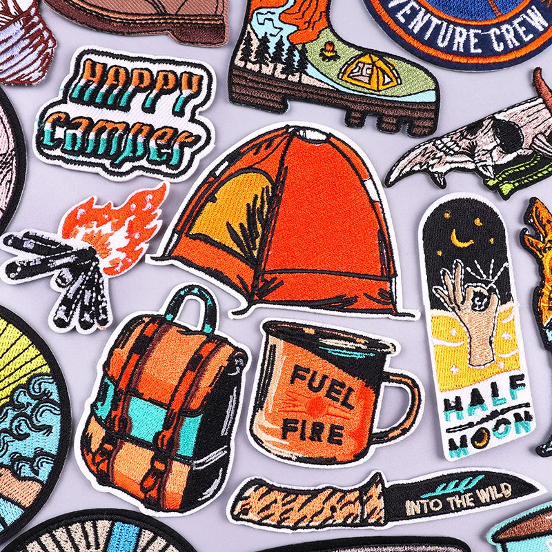 Collection of colorful camping-themed patches on a light gray background