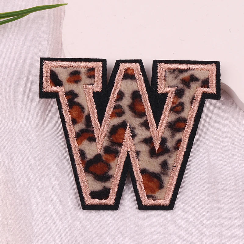 Leopard print letter 'W' patch on a light fabric background