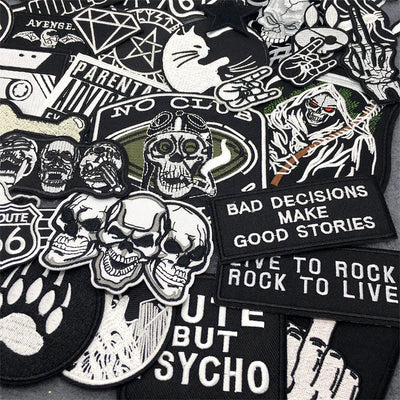 Collection of various black and white patches with text and graphics on a black background