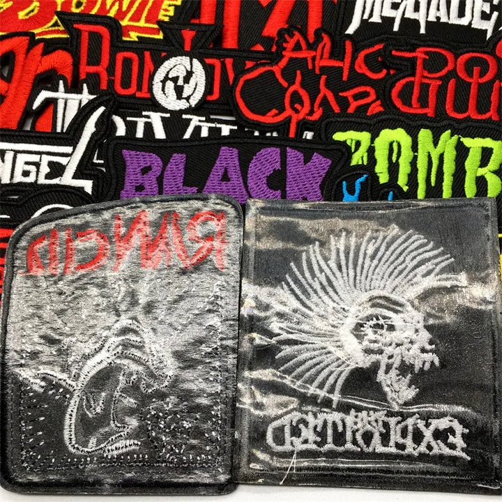 Collection of embroidered patches with various designs and text showing the backing too on a white background
