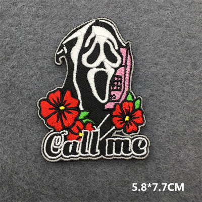 Embroidered patch with a skull design and flowers on a gray background