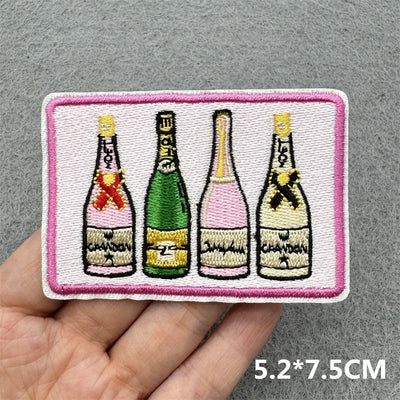 Embroidered patch with four champagne bottles on a gray background